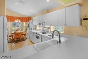 a kitchen with stainless steel appliances granite countertop a stove a sink a granite counter tops and a view of living room