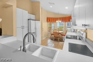 a living room with furniture a large window and kitchen view