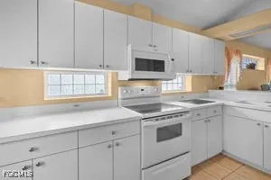 a kitchen with appliances a sink and a window