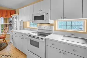 a kitchen with granite countertop a stove a sink and a microwave