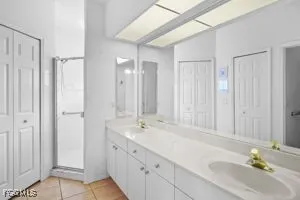 a bathroom with double vanity sinks and a shower