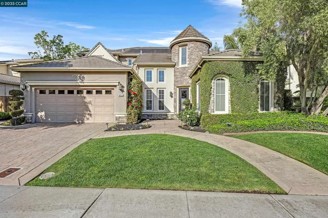 a front view of a house with a yard and potted plants