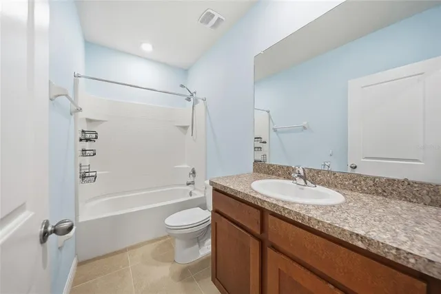 a bathroom with a granite countertop sink toilet tub and shower