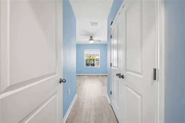 a view of a hallway with wooden floor and staircase