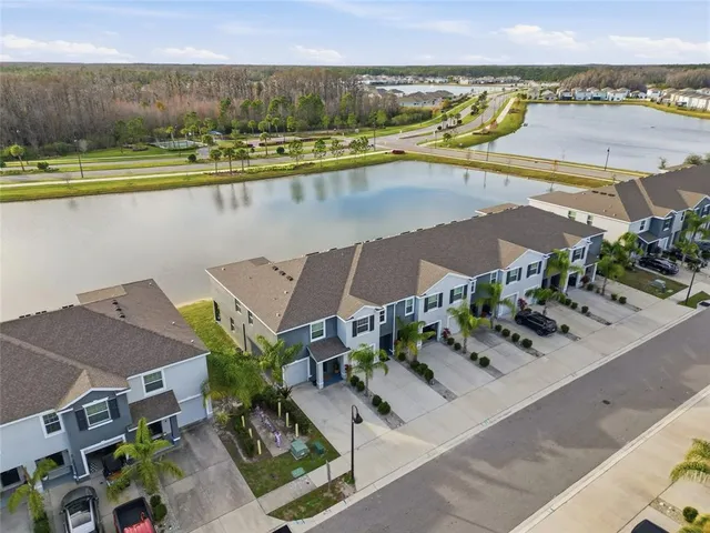 an aerial view of a house with a garden and lake view