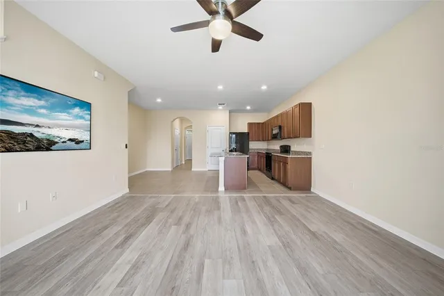 a view of kitchen with stainless steel appliances refrigerator stove and wooden floor