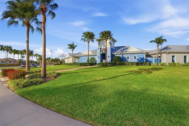 a view of a house with a big yard and palm trees