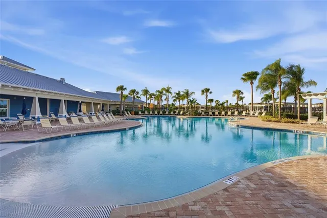 a view of swimming pool with outdoor seating and lake view
