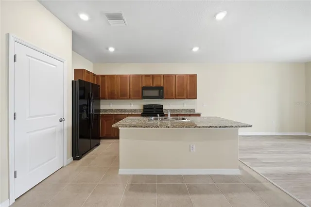 a kitchen with stainless steel appliances granite countertop a stove a sink and a refrigerator