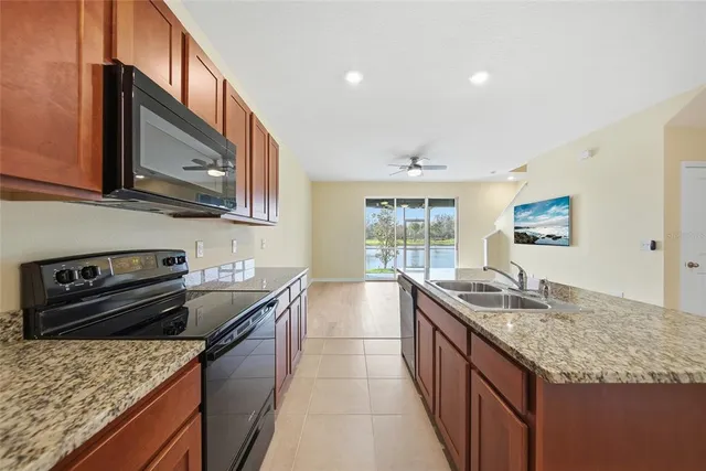 a kitchen with stainless steel appliances granite countertop a sink stove and cabinets