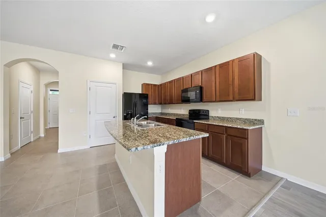 a kitchen with stainless steel appliances granite countertop a stove refrigerator sink and cabinets
