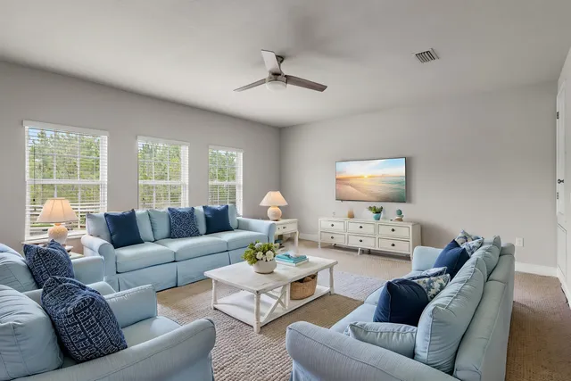 an empty room with an entryway and chandelier fan