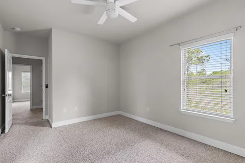 an empty room with a window and a ceiling fan
