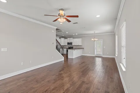 a view of a livingroom with wooden floor and ceiling fan
