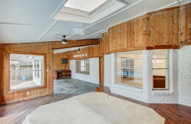 a view of a hall with wooden floor and windows