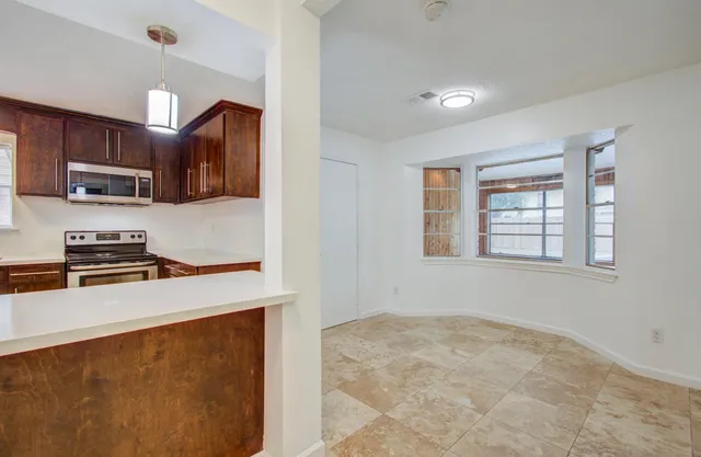 a kitchen with wooden cabinets and a stove top oven