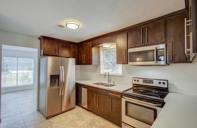 a kitchen with stainless steel appliances granite countertop a refrigerator stove and sink