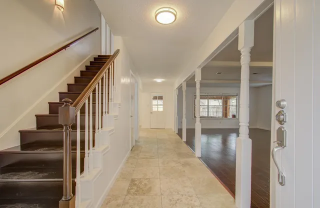 a view of a hallway with wooden floor and staircase