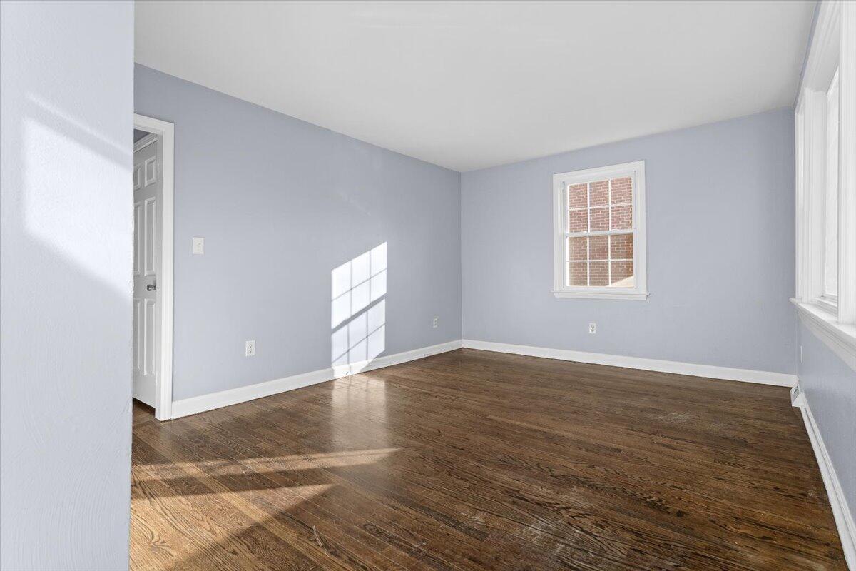 2617 Radford Road Northeast Roanoke, VA 24012 - Photo 4 of 25 an empty room with wooden floor and windows