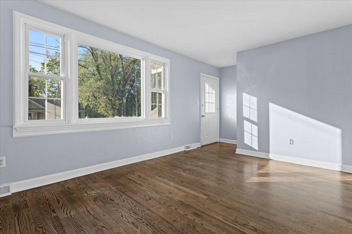 2617 Radford Road Northeast Roanoke, VA 24012 - Photo 5 of 25 a view of an empty room with wooden floor and a window