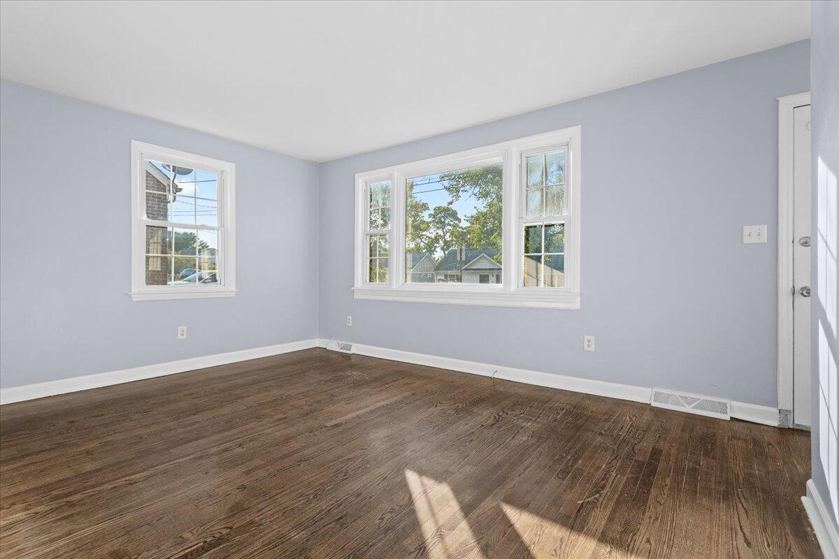 2617 Radford Road Northeast Roanoke, VA 24012 - Photo 6 of 25 a view of an empty room with wooden floor and a window