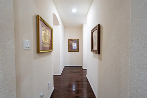 a view of a hallway with wooden floor and closet