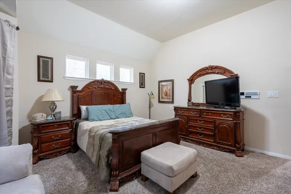 a bedroom with a bed and dresser with mirror
