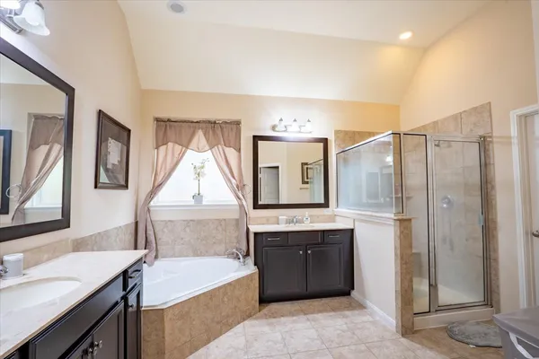 a bathroom with a tub sink and mirror