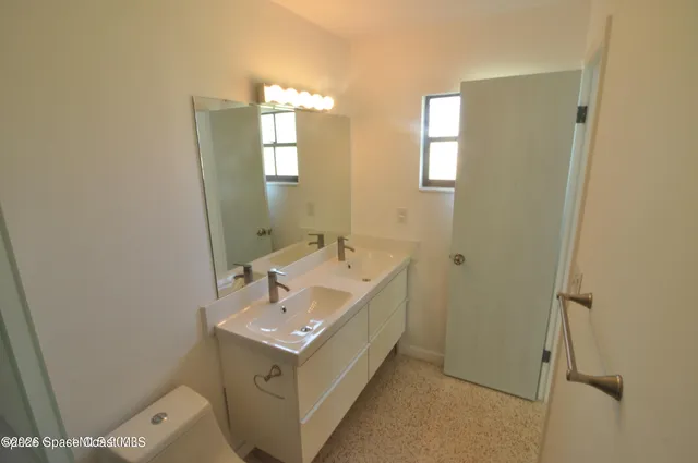 a bathroom with a sink a toilet and mirror