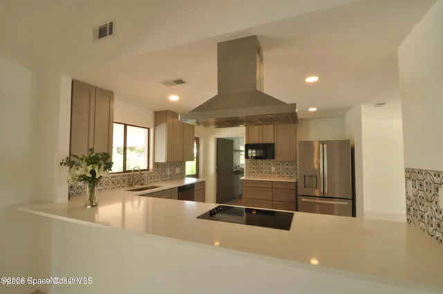 a view of a kitchen with refrigerator and a stove