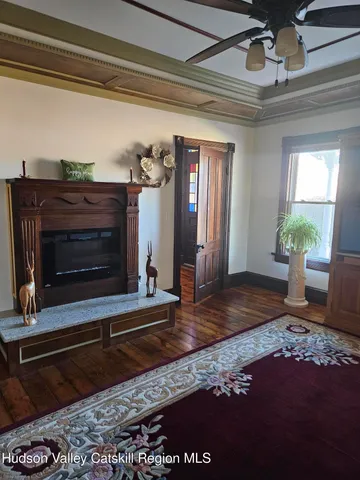 a living room with a fireplace and wooden floor