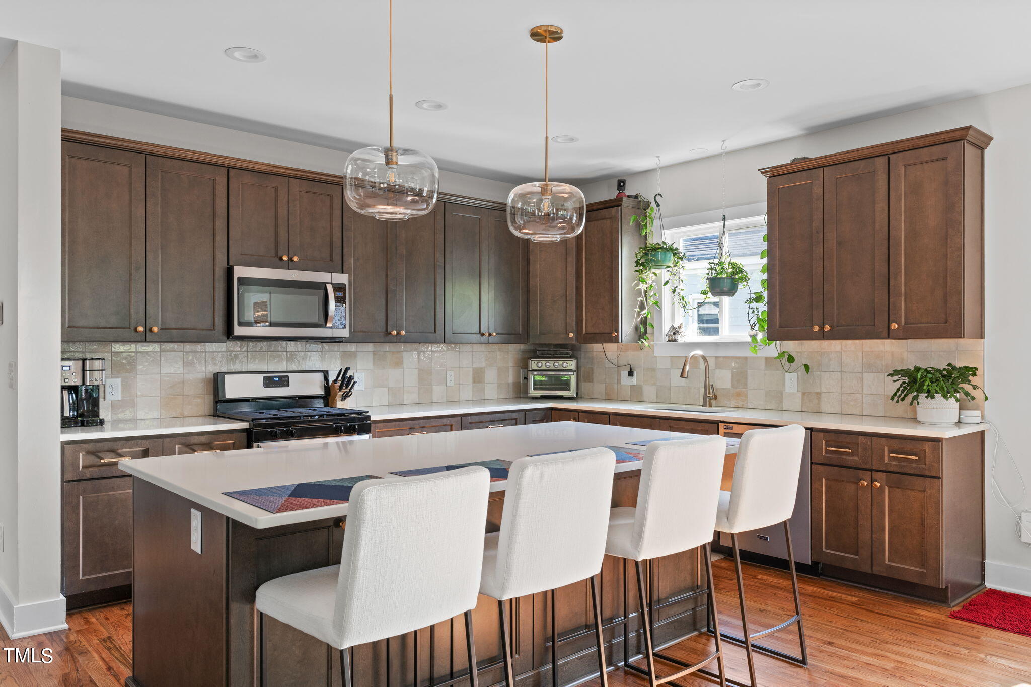 312 East Lee Street Raleigh, NC 27601 - Photo 12 of 48 a kitchen with a center island a window cabinets and stainless steel appliances