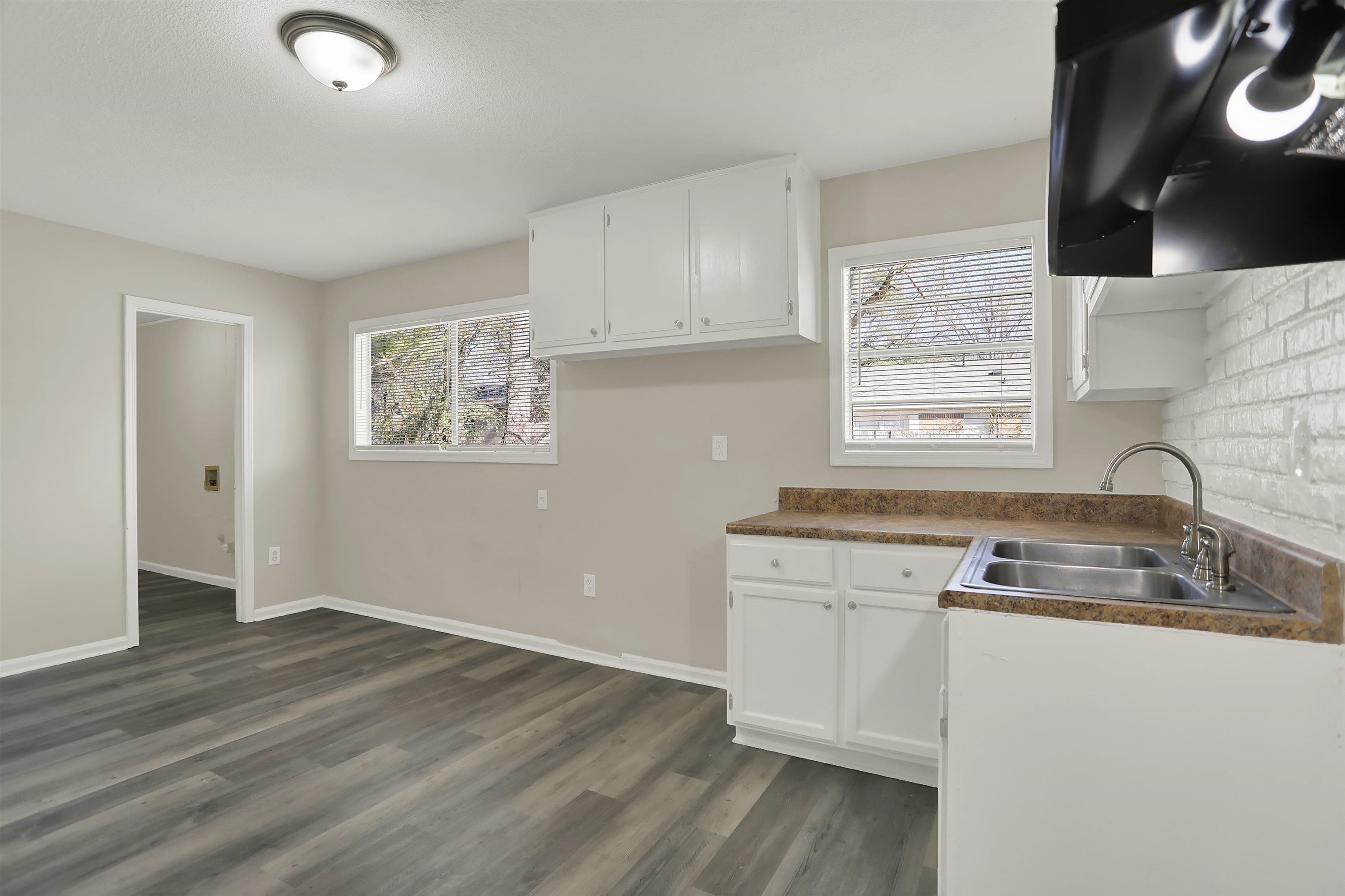 3716 Ridgemont Road Memphis, TN 38128 - Photo 10 of 30 a kitchen with granite countertop white cabinets and wooden floor