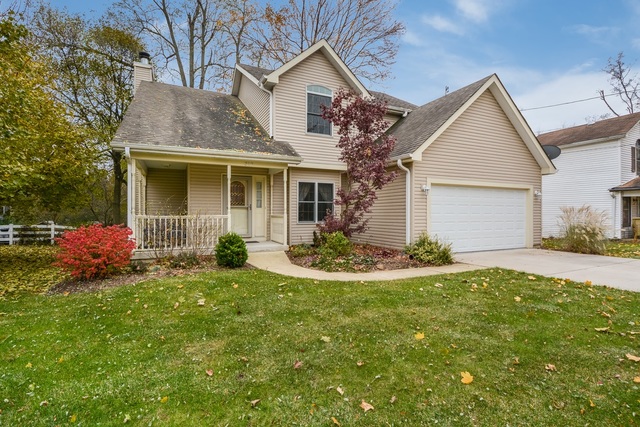 a view of a house with a yard and fire pit