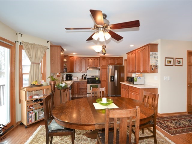 312 Main Street Oswego, IL 60543 - Photo 11 of 29 a kitchen with stainless steel appliances kitchen island granite countertop a table chairs and a refrigerator
