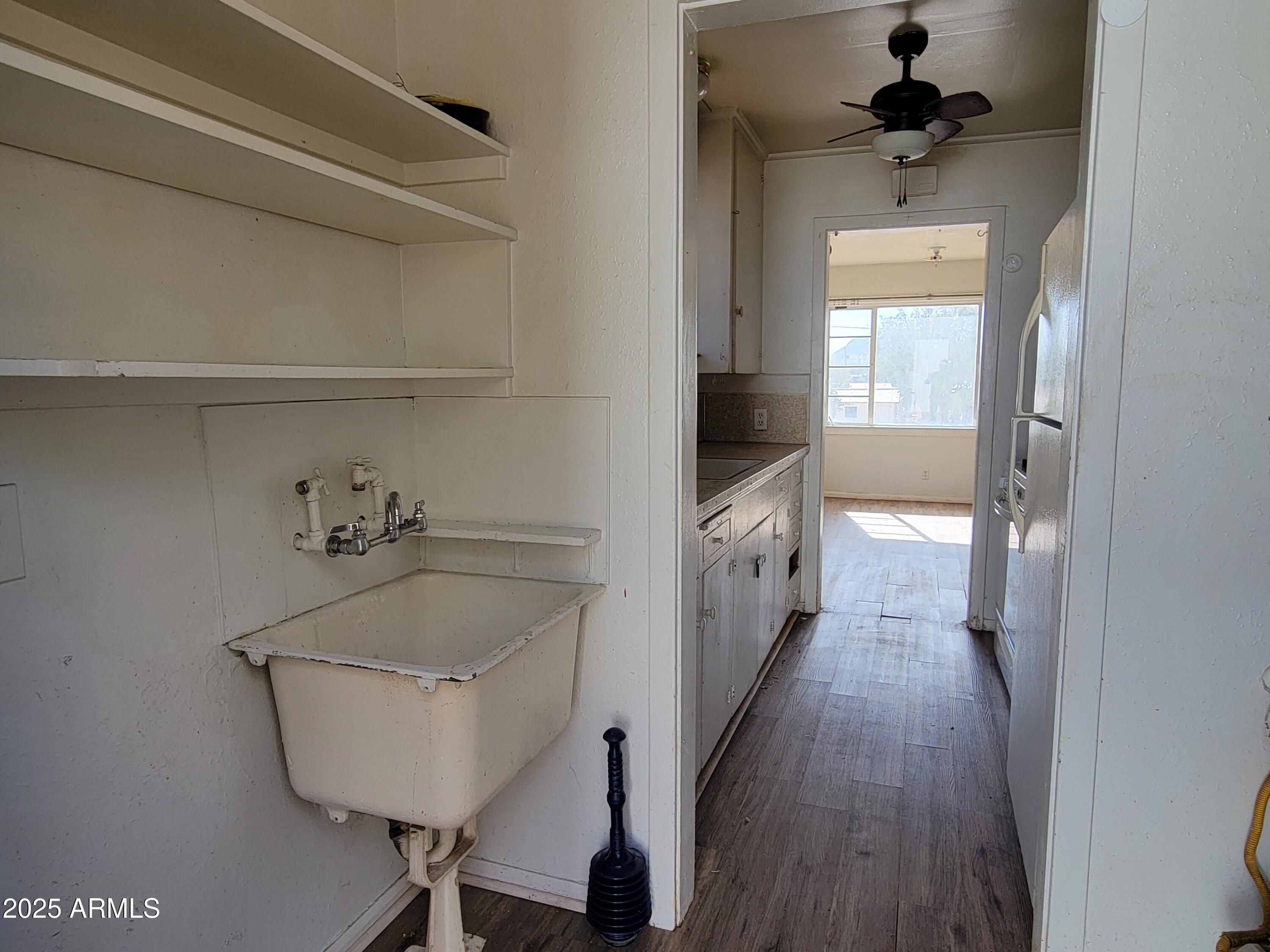 53 Spray Avenue Bisbee, AZ 85603 - Photo 4 of 21 a hallway with a sink and a wooden floor