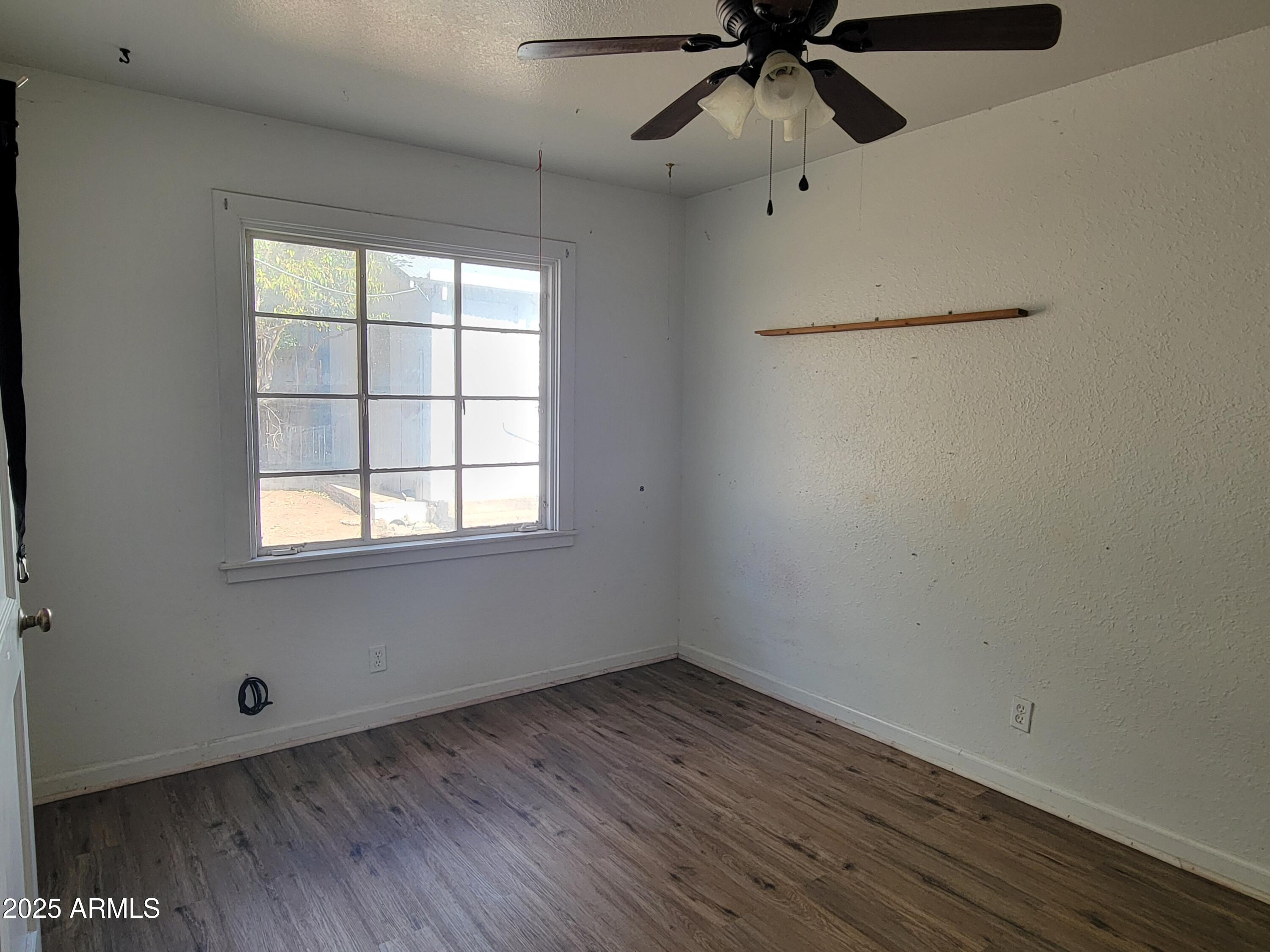 53 Spray Avenue Bisbee, AZ 85603 - Photo 10 of 21 an empty room with a window and a ceiling fan