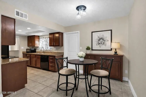 a kitchen with stainless steel appliances kitchen island granite countertop a dining table and chairs