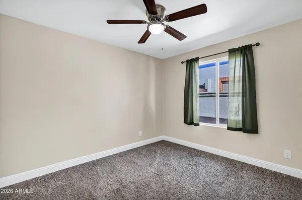 an empty room with windows and fan
