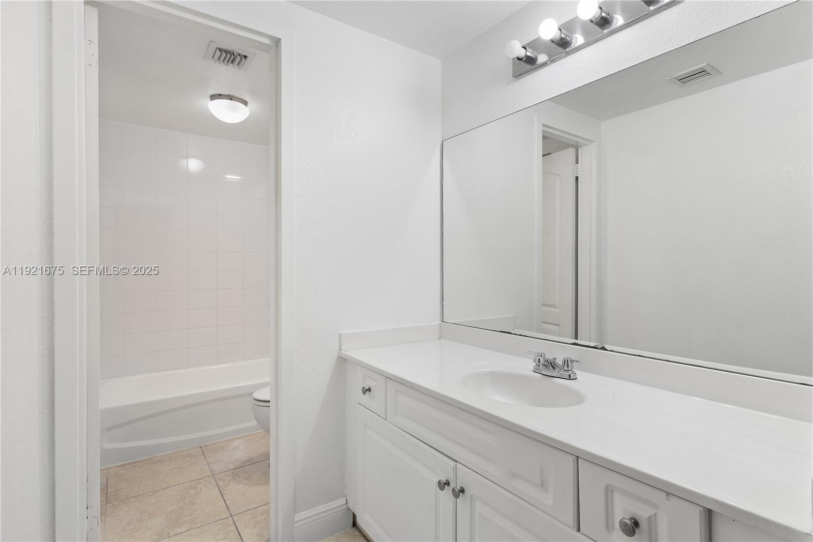 5102 Northwest 79th Avenue, Unit 304 Doral, FL 33166 - Photo 16 of 25 a bathroom with a sink vanity and a mirror