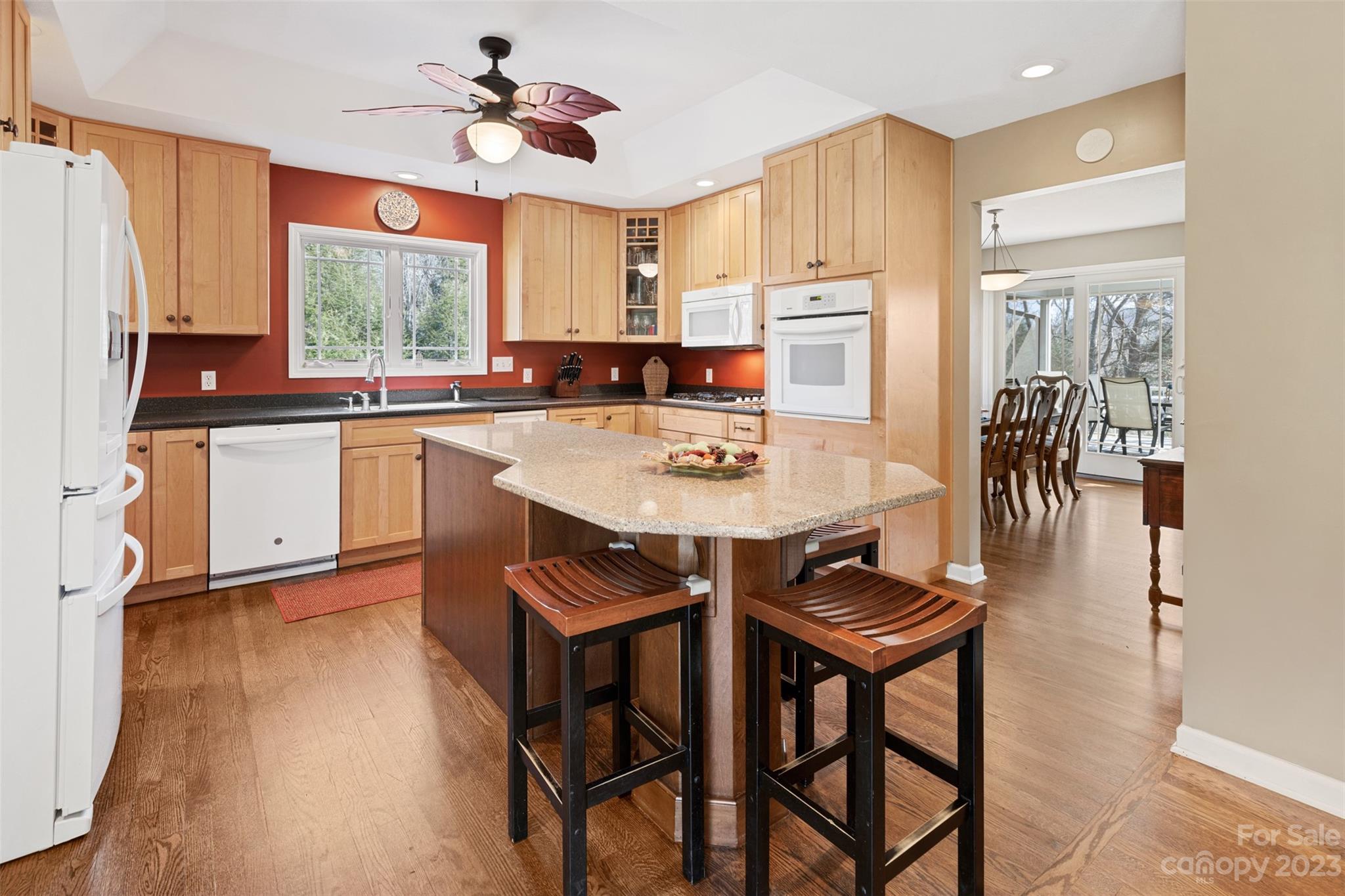 36 Wild Wind Trail Fairview, NC 28730 - Photo 13 of 33 a kitchen with stainless steel appliances granite countertop a stove a refrigerator a sink a dining table and chairs with wooden floor