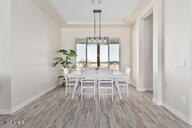 23109 West Skinner Road Wittmann, AZ 85361 - Photo 17 of 39 a dining room with furniture a chandelier and wooden floor