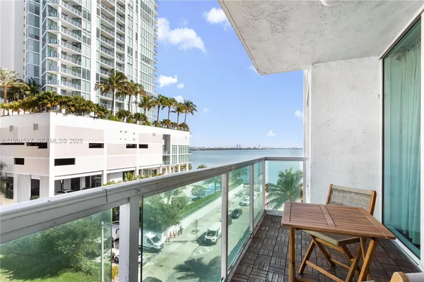 a view of a balcony with chairs and wooden fence