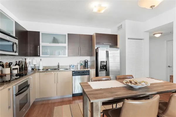 a kitchen with granite countertop a sink stove and refrigerator
