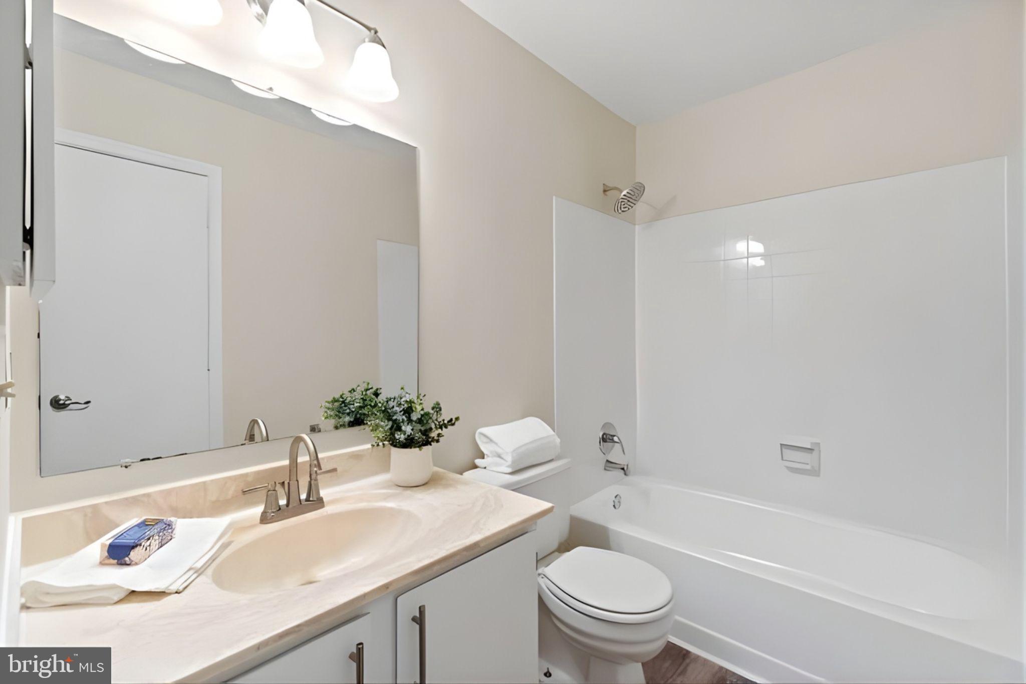 107 St Charles Square Sterling, VA 20164 - Photo 20 of 27 a bathroom with a granite countertop sink a toilet and shower