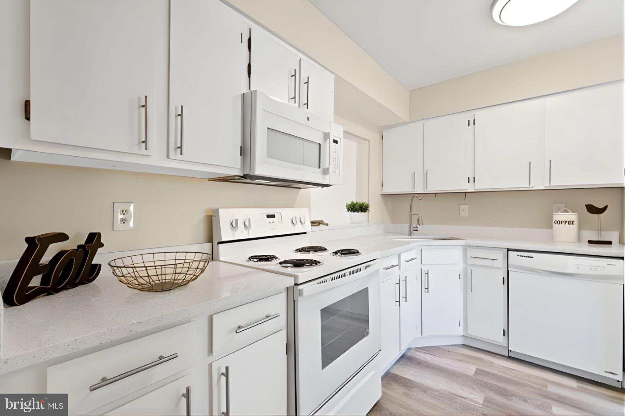 107 St Charles Square Sterling, VA 20164 - Photo 2 of 27 a kitchen with granite countertop white cabinets and white appliances