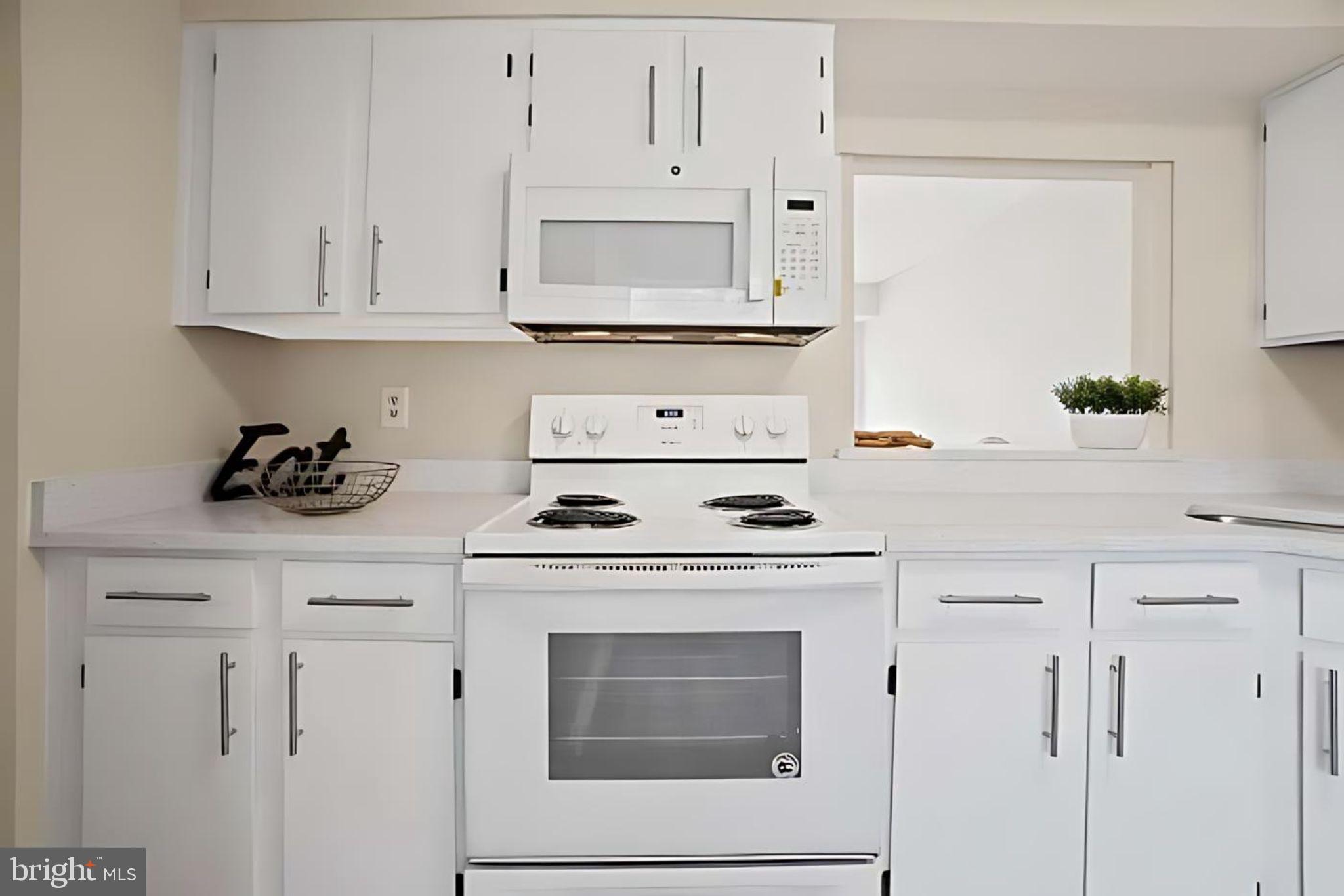 107 St Charles Square Sterling, VA 20164 - Photo 3 of 27 a white kitchen with granite countertop white cabinets and white stove