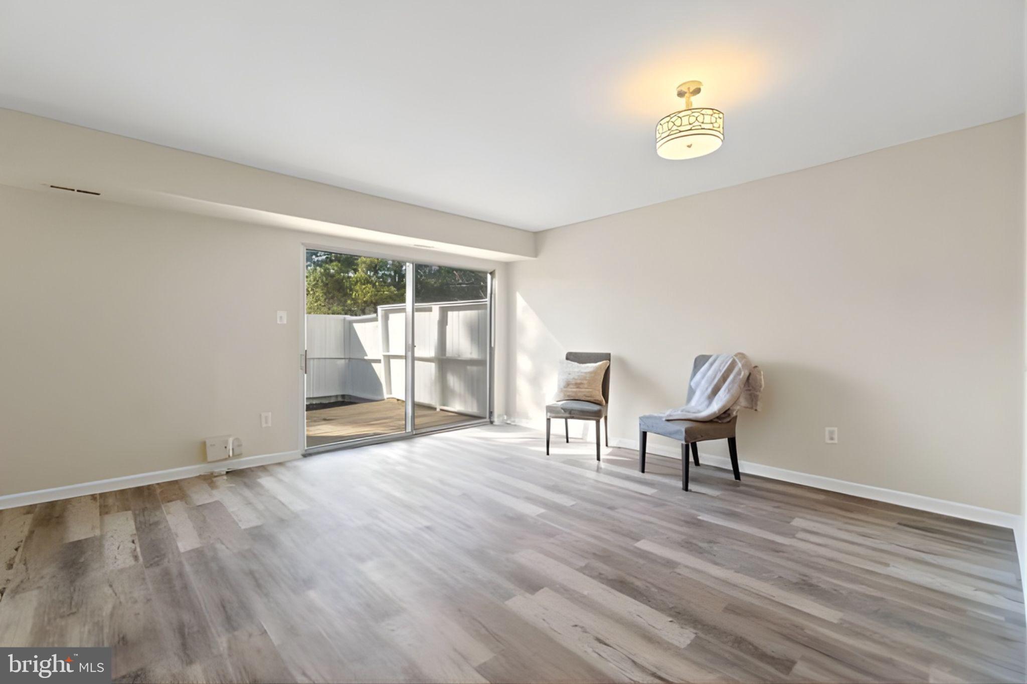 107 St Charles Square Sterling, VA 20164 - Photo 5 of 27 a view of an empty room with a window and wooden floor