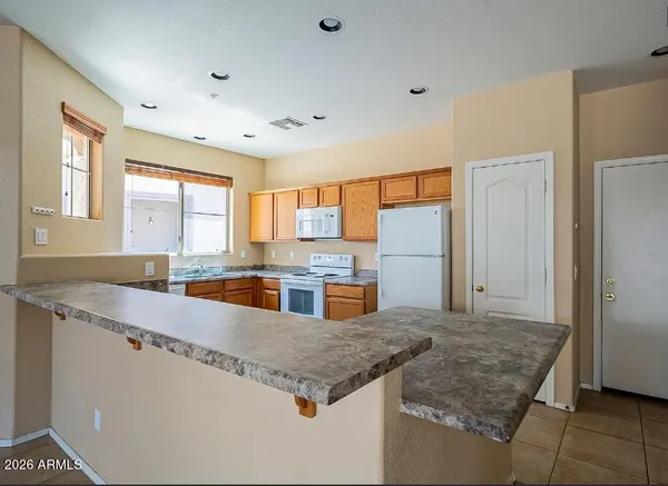 a kitchen with stainless steel appliances granite countertop a sink and a refrigerator
