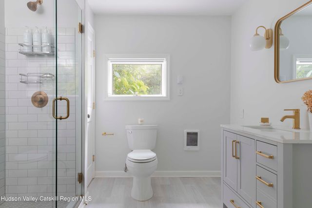 a bathroom with a toilet sink a shower and mirror